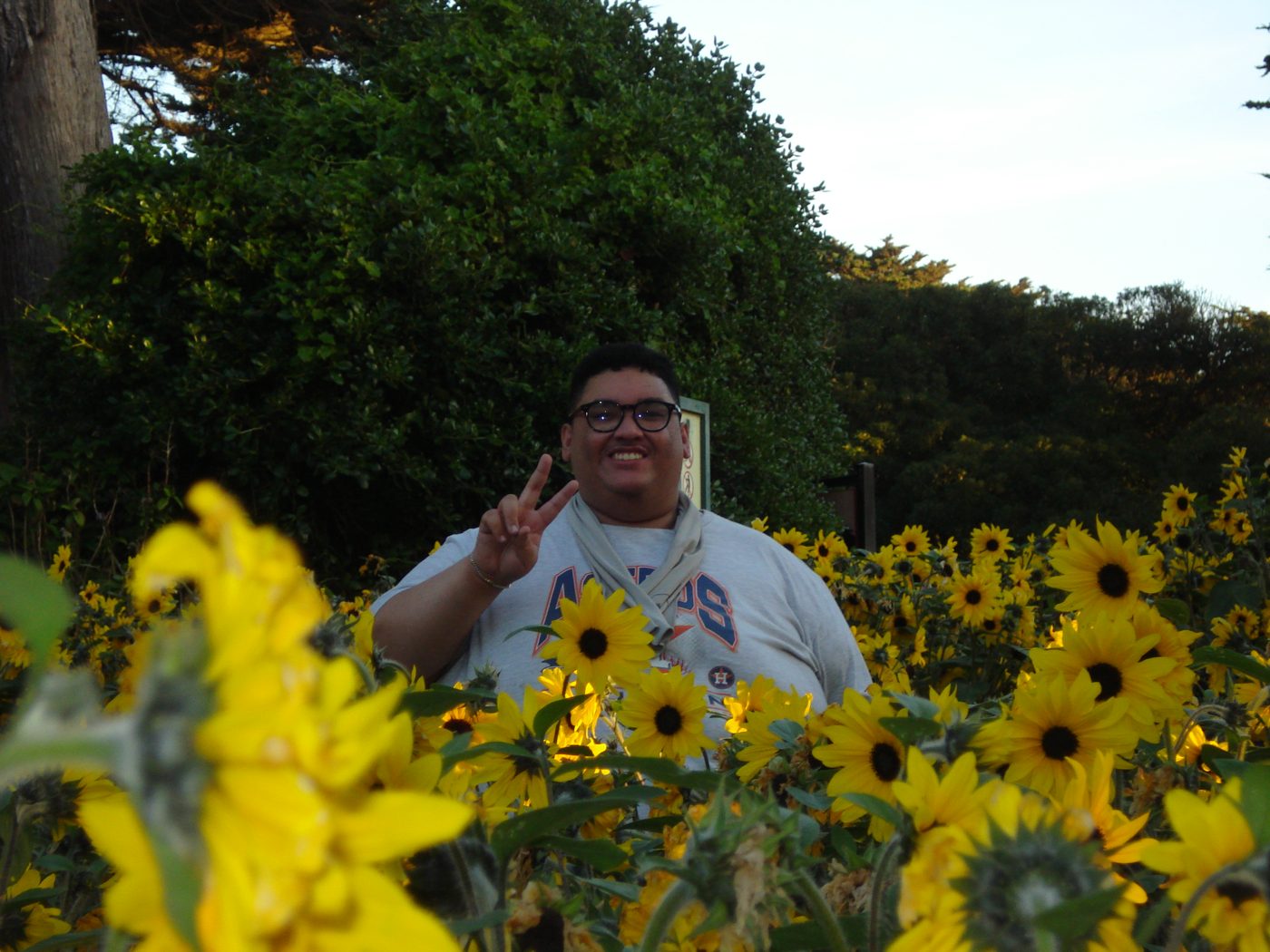 Jorell smiling in a field of sunflowers