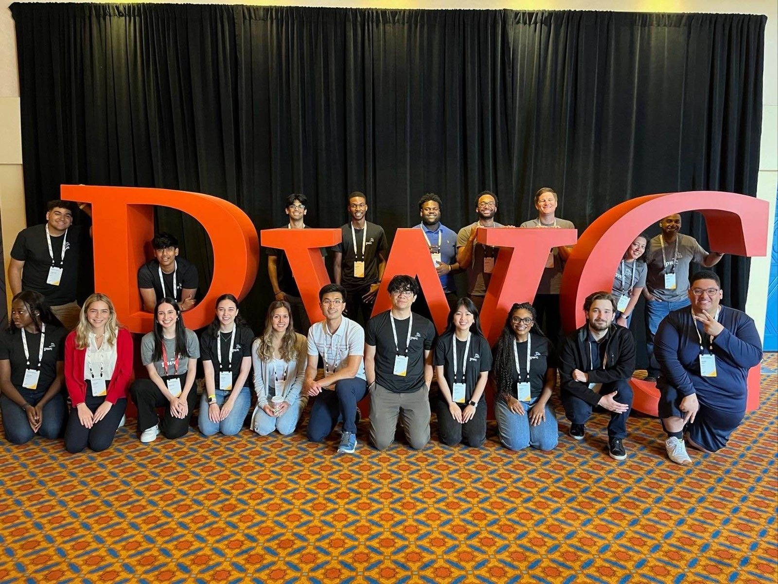 PwC interns posing with giant PwC letters at an intern event
